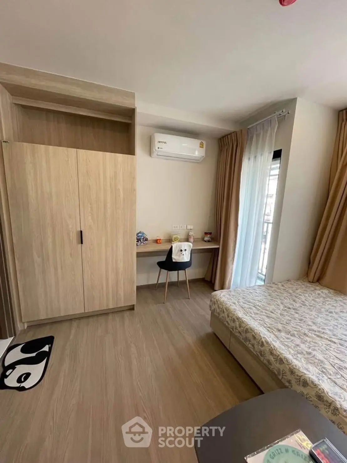 Cozy bedroom with modern furnishings and natural light, featuring a built-in wardrobe and air conditioning.