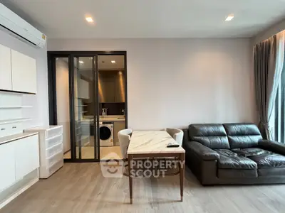 Modern living room with sleek furniture and open kitchen layout in a stylish apartment.