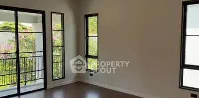 Bright and airy room with large windows and garden view, perfect for a serene living space.