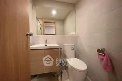 Modern bathroom with sleek fixtures and large mirror in a contemporary home.