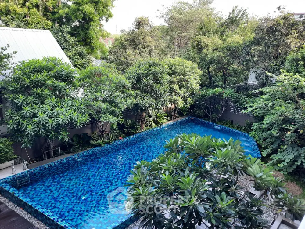 Luxurious residential pool surrounded by lush greenery offering a serene oasis in the city.
