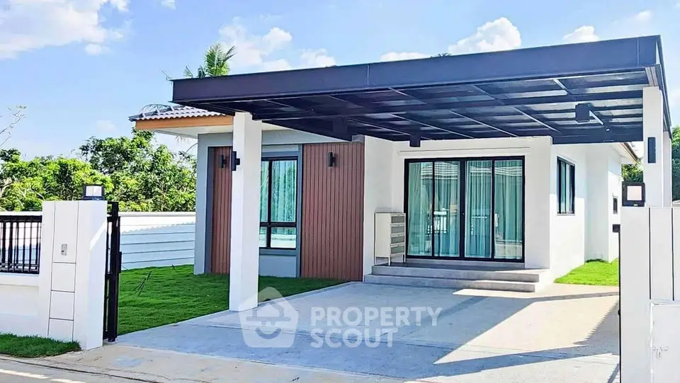 Modern single-story house with carport and lush green surroundings