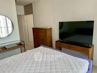 Modern bedroom with sleek furniture and large TV, perfect for relaxation and entertainment.