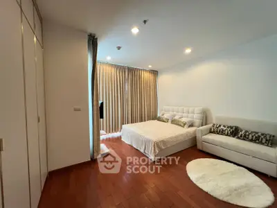 Spacious modern bedroom with elegant decor and wooden flooring