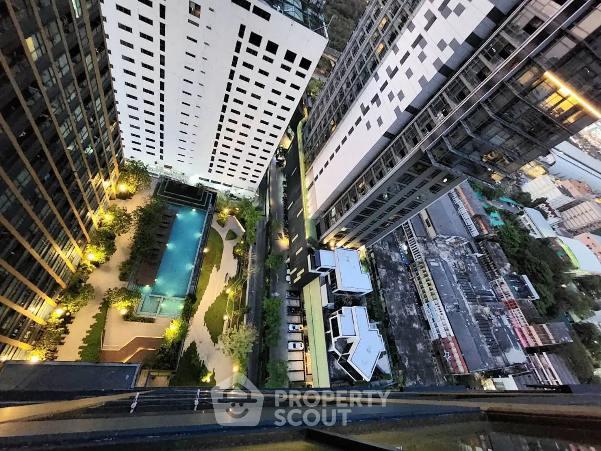 Stunning high-rise view showcasing modern architecture and illuminated pool area in urban setting.