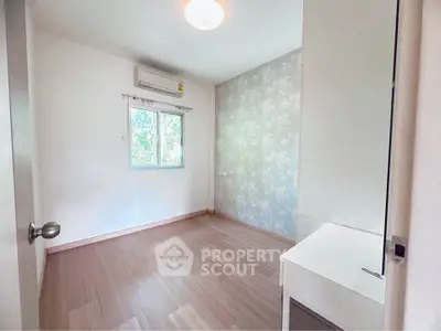 Bright and airy bedroom with floral accent wall and wooden flooring