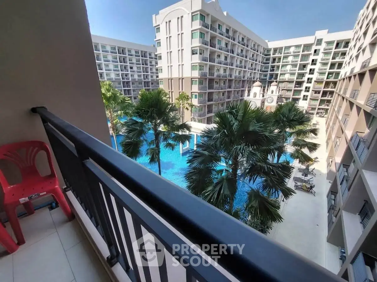 Stunning view from balcony overlooking luxurious pool and modern apartment complex.