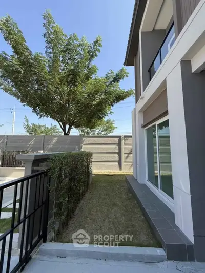 Modern two-story house exterior with lush greenery and sleek design.