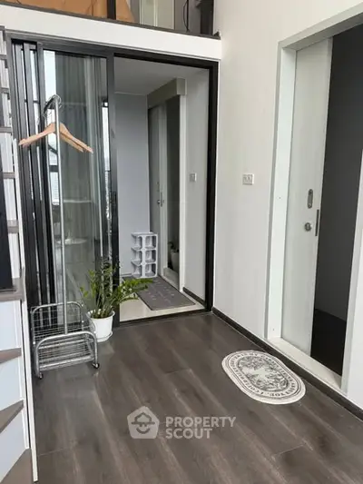 Modern apartment entrance with sleek flooring and glass sliding doors