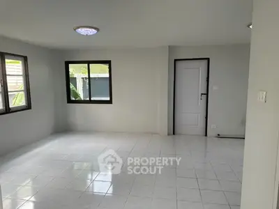 Spacious empty living room with tiled floor and large windows