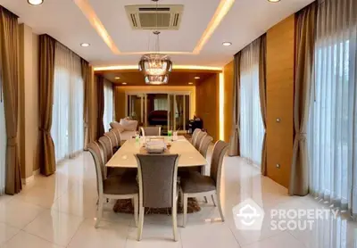 Luxurious dining room with elegant long table, plush chairs, and sophisticated lighting, complemented by warm tones and refined decor.