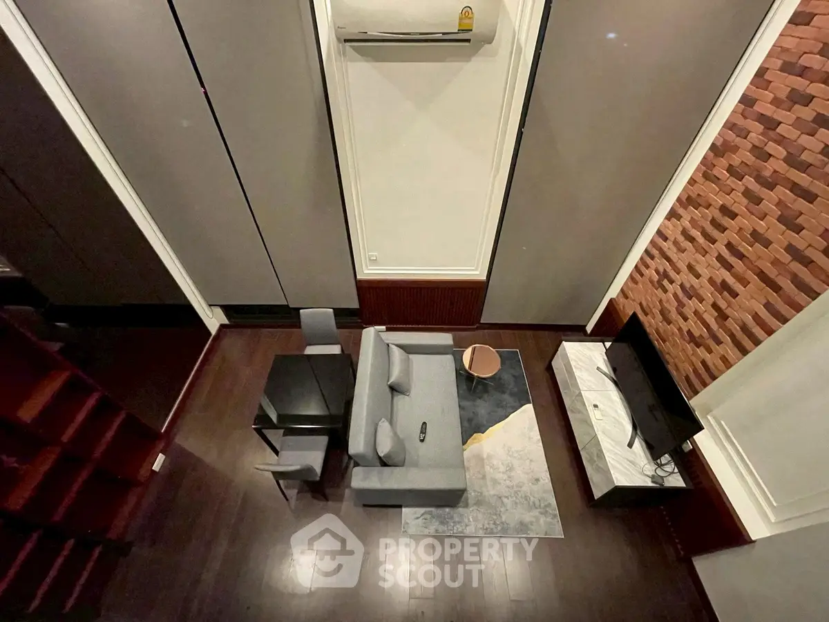 Modern living room with high ceiling, stylish furniture, and wall-mounted TV for a cozy atmosphere.