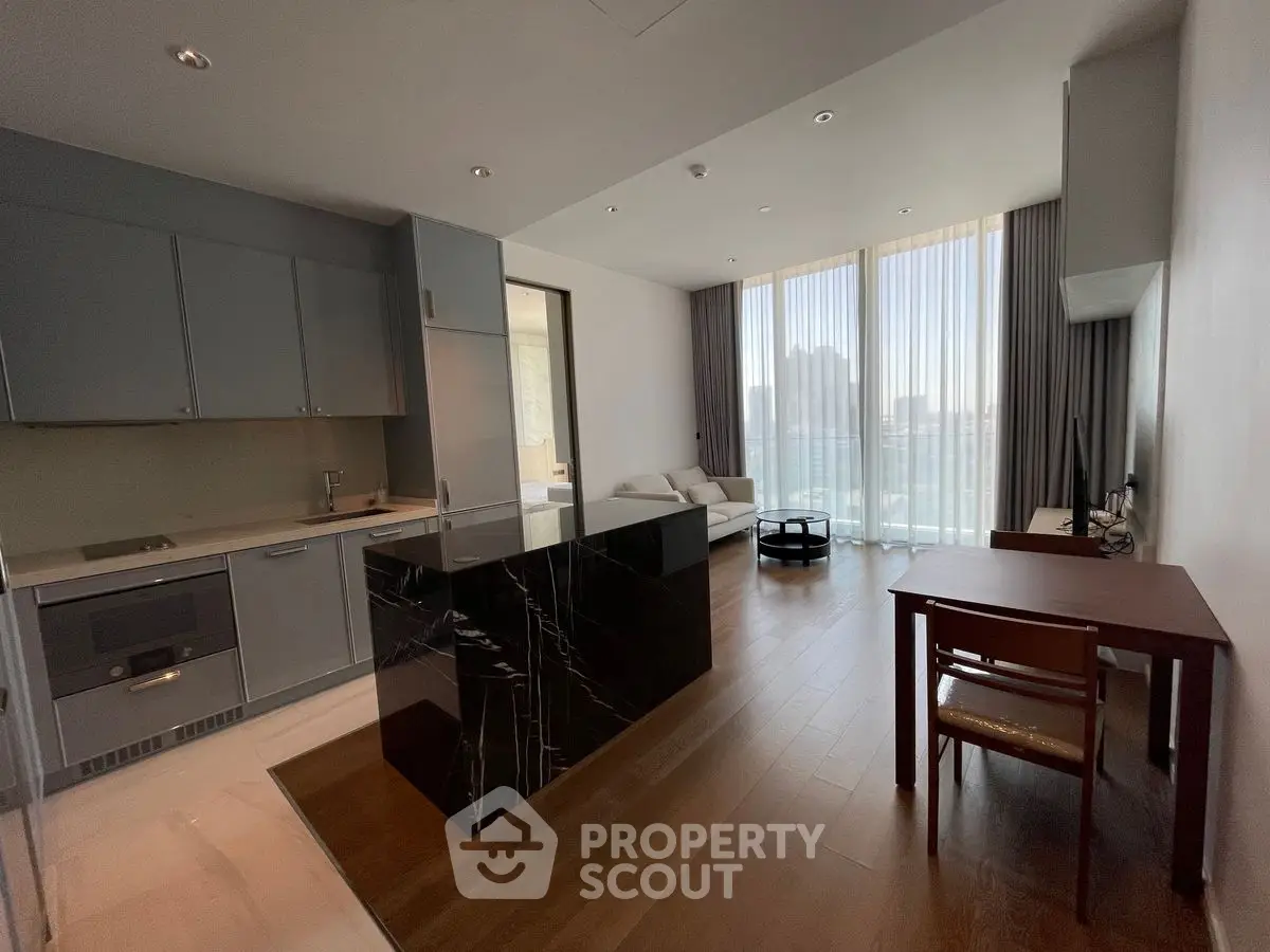 Modern open-plan kitchen and living area with floor-to-ceiling windows and sleek design.