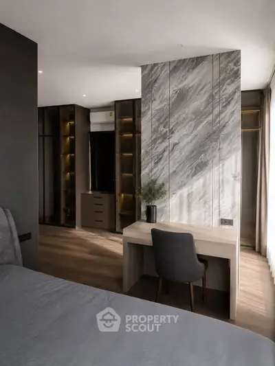 Modern bedroom with elegant marble accent wall and stylish workspace