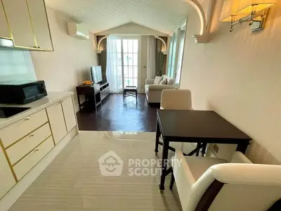 Elegant living room with open kitchen, featuring modern furniture and natural light.