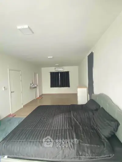 Spacious bedroom with modern decor and large bed in a minimalist style apartment.