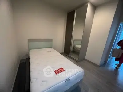 Cozy bedroom with single bed and mirrored wardrobe in modern apartment