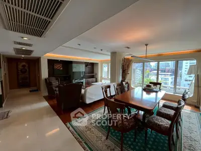 Spacious living and dining area with city view, elegant furniture, and natural light.