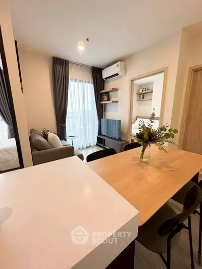 Modern living room with open layout and stylish decor, featuring a cozy sofa and wall-mounted TV.