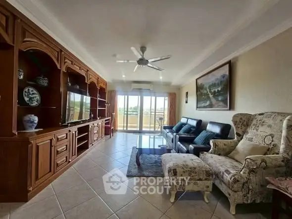 Spacious living room with elegant furniture and large windows leading to a balcony.