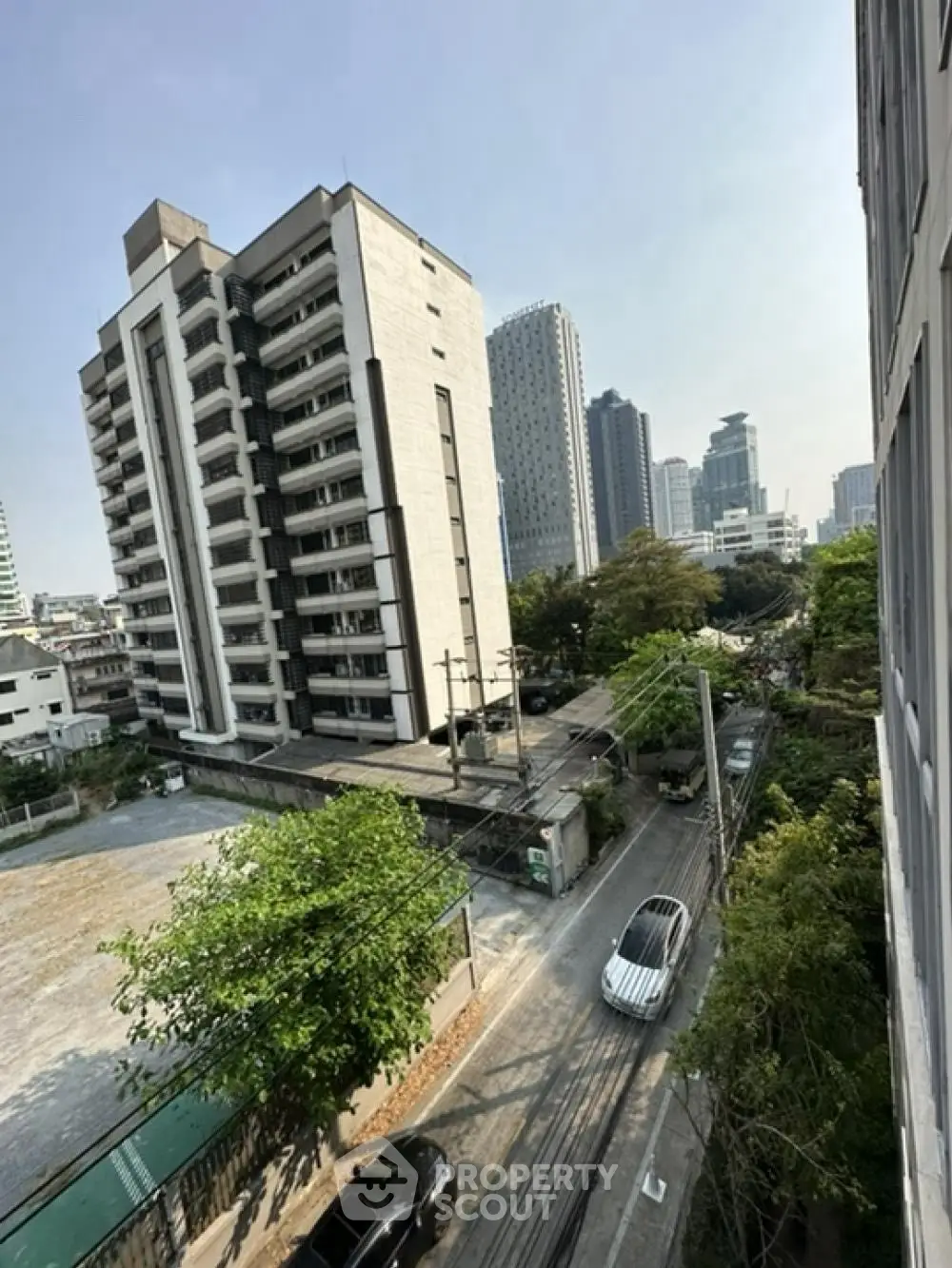 Urban cityscape view with modern high-rise buildings and street below, showcasing vibrant city living.