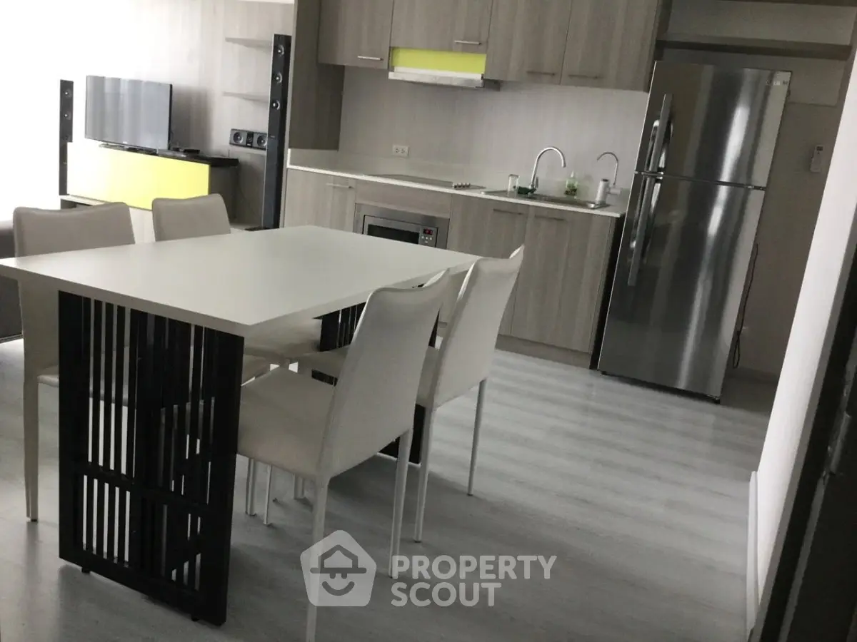 Modern kitchen with sleek appliances and dining area in stylish apartment