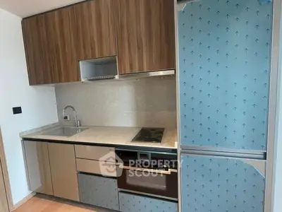 Modern compact kitchen with sleek cabinetry and built-in appliances in a stylish apartment.