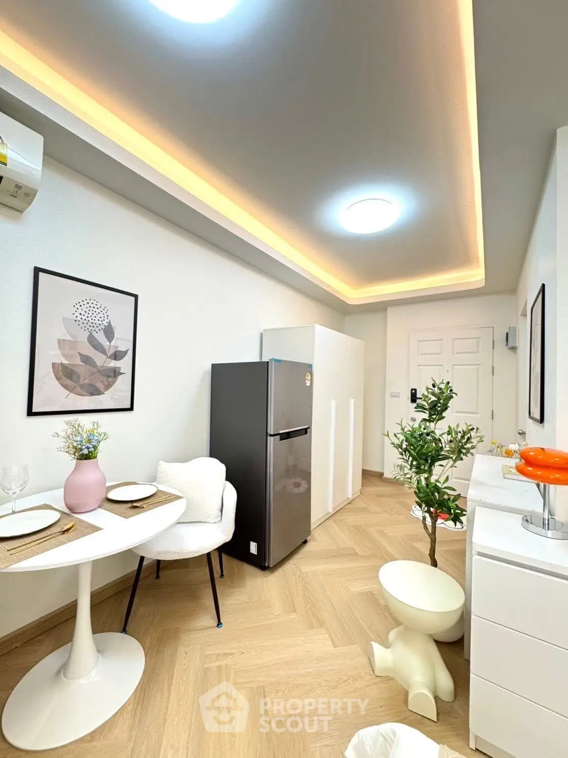 Modern kitchen with sleek design, featuring a dining area and stainless steel fridge.