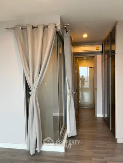 Modern apartment hallway with glass partitions and elegant curtains
