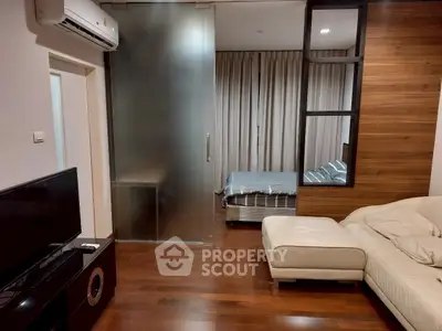 Modern apartment interior with living room and bedroom, featuring sleek wooden flooring and stylish furnishings.