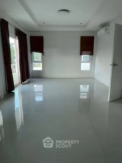Spacious empty room with large windows and glossy tiled floor, perfect for customization.