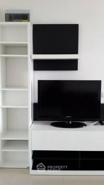 Modern living room with sleek TV unit and shelving, perfect for stylish urban living.