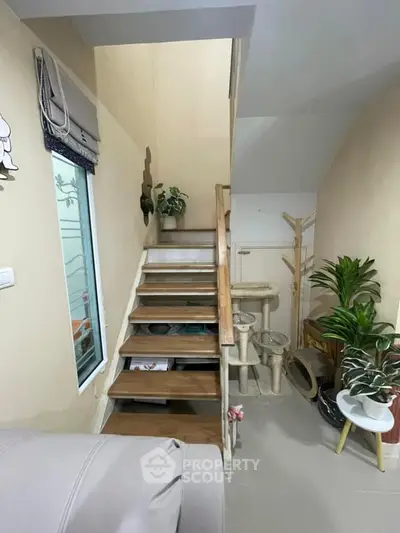 Cozy interior with wooden staircase and indoor plants, perfect for modern living.