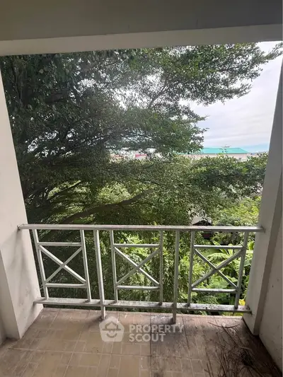 Charming balcony with lush greenery and partial ocean view, perfect for relaxation and enjoying nature.