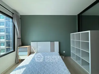 Modern bedroom with large windows and stylish shelving unit in a high-rise apartment.