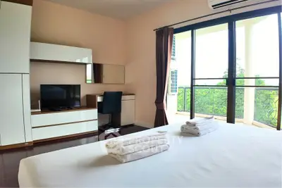 Spacious bedroom with balcony view and modern furnishings