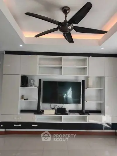 Modern living room with sleek entertainment center and ceiling fan