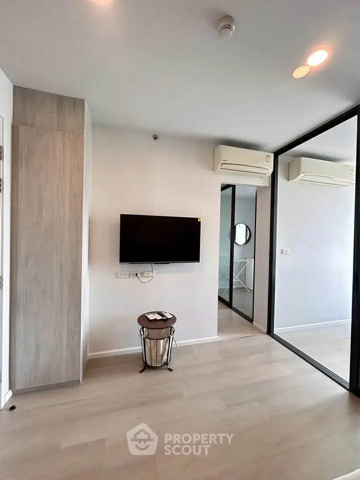 Modern living room with wall-mounted TV and air conditioning in a stylish apartment.