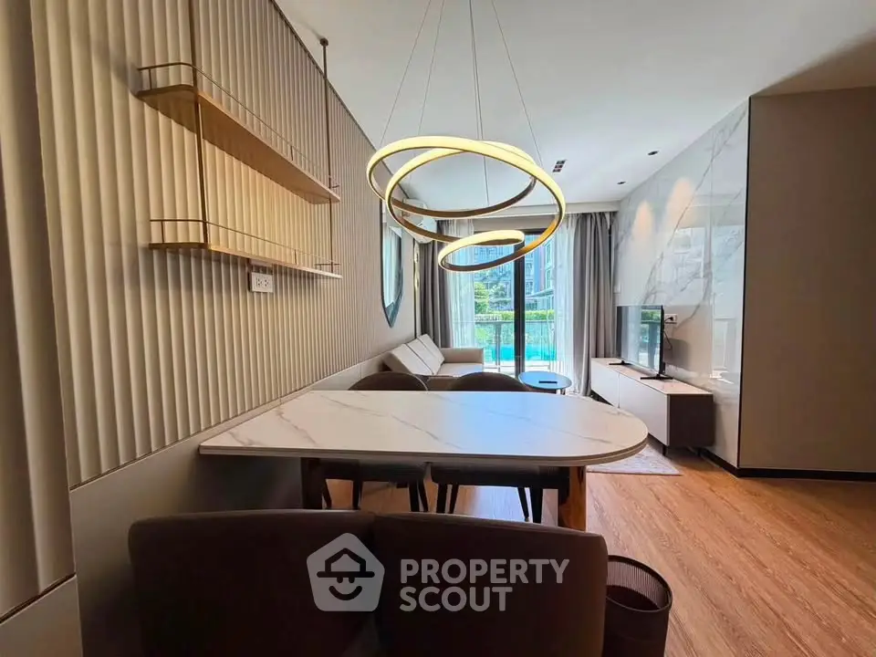 Modern living room with stylish lighting and pool view, featuring elegant furniture and contemporary design.