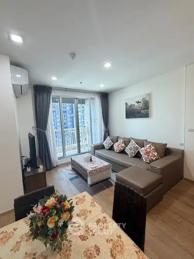 Spacious modern living room with large sofa and balcony view in a stylish apartment.