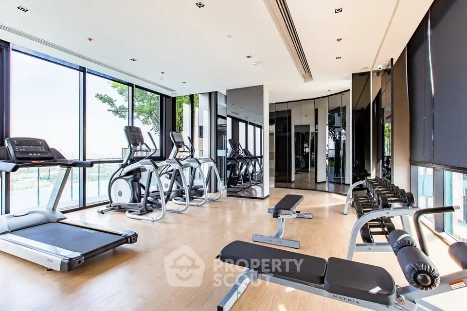 Modern gym with state-of-the-art equipment and floor-to-ceiling windows offering a scenic view.