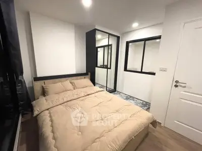 Modern bedroom with cozy bedding and sleek design in a stylish apartment.