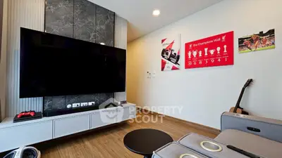 Modern living room with large TV and stylish decor, perfect for entertainment.