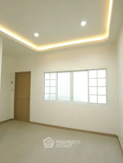 Bright empty room with modern ceiling lights and large window