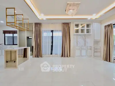 Luxurious open-plan living area with elegant chandelier and modern kitchen design.