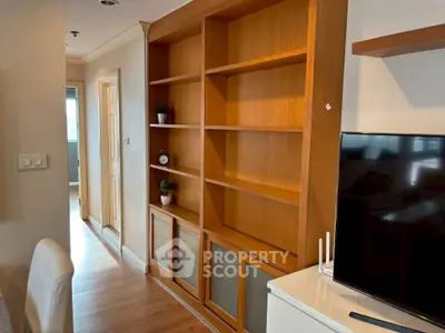 Spacious living room with built-in wooden shelves and modern TV setup