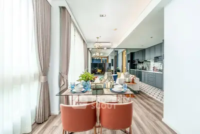 Luxurious open-plan living and dining area with modern kitchen in a bright, elegant apartment.