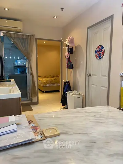 Cozy interior view featuring a kitchen and bedroom with modern decor and ample lighting.