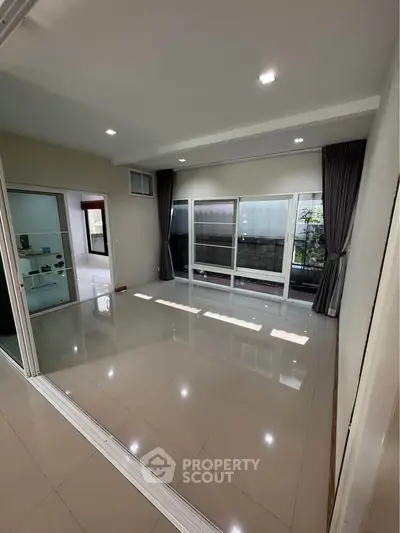 Spacious living room with large windows and sliding doors, perfect for natural light.