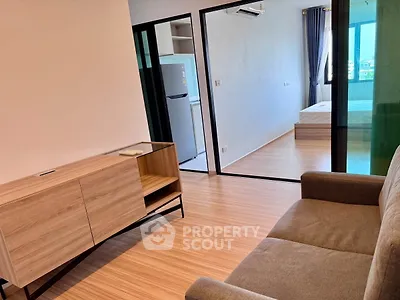 Modern apartment interior with open layout, featuring a cozy living area and a glimpse of the bedroom.
